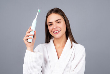 Smiling young woman with healthy teeth holding a tooth brush. Human teeth. Dental health care clinic. Close-up of a young woman is brushing her teeth. White tooth.