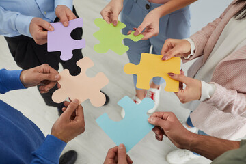 Group of people joining jigsaw puzzle parts. Creative business team come up with different ideas...