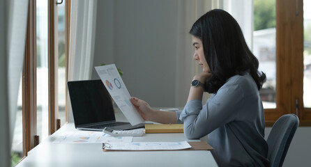 Asian businesswoman working in the office with working documents.