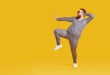 Funny fat fashion guy in pajamas posing on copy space background. Full length portrait of happy...