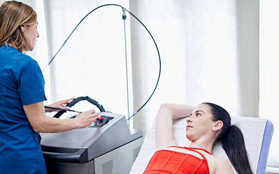 Beautician preparing epilation machine near client