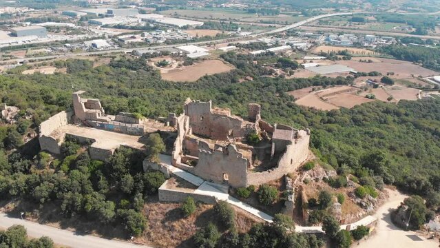 stunning orbiting aerial of Castell de Palafolls located in Palafolls, Barcelona, Cataluña, Spain.  The castle ruins are a major tourist attraction and have a long history. since medieval times.