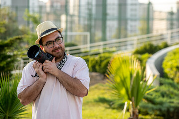 photographer on the photoshoot in hat at park with camera professional guy loving camera