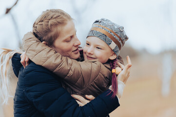 Fototapeta premium Loving mom and her little daughter embrace each other in a moment of love emotion