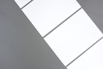 Empty white rectangle poster mockups lying diagonally on a dark gray background
