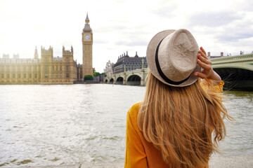 Tourism in London. Back view of tourist woman enjoying sight of Westminster palace and bridge on...