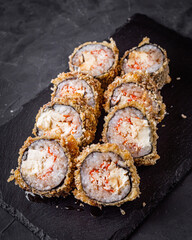 delicious sushi rolls on a black stone background © Narsil