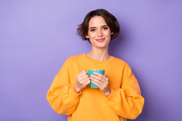 Portrait of attractive cheerful girl drinking herbal tea pause break isolated over violet lilac color background