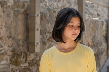 Fototapeta na wymiar Portrait of a young girl posing against a stone wall.