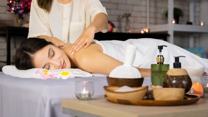 Obraz na płótnie Canvas Asian woman lying in bed doing spa with smiling, happy, relaxing face in candlelight. warm atmosphere She was massaged by the spa staff on her face and shoulders making her feel very comfortable.