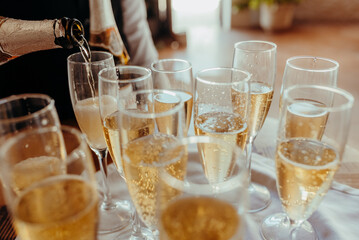 Champagne glasses filled by a waiter to celebrate good news with alcohol.
