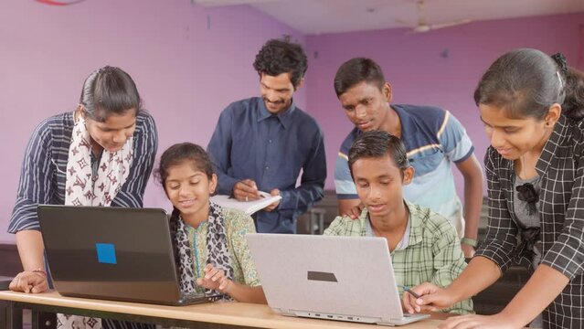 Groups of students seriously using laptop at classroom for studying project work by making notes online - concept of technology, education and self learning