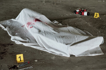 White sheet with stains of blood covering dead body shot with handgun or killed by knife or some...