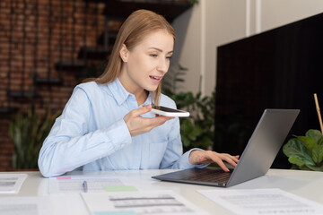 Businesswoman with phone talking with partner when working at home