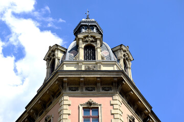Fototapeta na wymiar Classic old decorative roof dormer detail in Budapest. blue sky. white clouds. closeup building detail. architecture, travel, tourism concept. summer season. zink dome and roof cover. stucco facade.