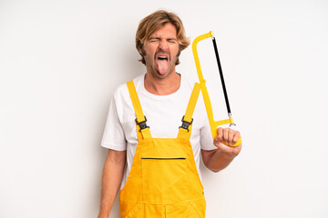 adult blond man with cheerful and rebellious attitude, joking and sticking tongue out. handyman...