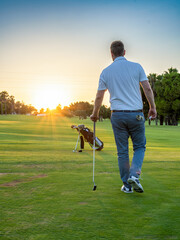 Back vie of Golf player man at the course. - obrazy, fototapety, plakaty