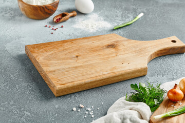 Food mockup. Empty wooden board on concrete table with pastry ingredients. Wooden board  with...