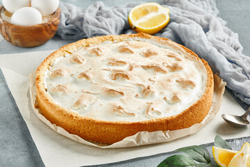 Sweet bakery - lemon tart with meringue on gray stone background. Lemon pie with mousse in rustic style on stone table. Aesthetic composition with lemon tart. Citrus tart with meringue. - obrazy, fototapety, plakaty