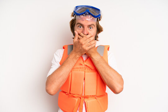 adult blond man covering mouth with hands with a shocked. life jacket concept