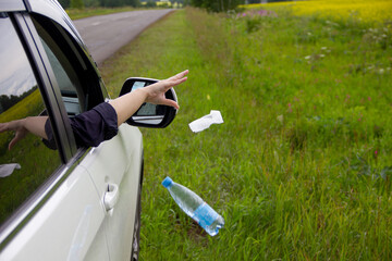 a person throws garbage from the car window to the side of the road