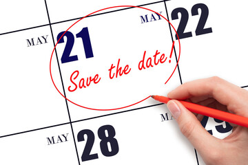 21st day of May. Hand drawing red line and writing the text Save the date on calendar date May 21....
