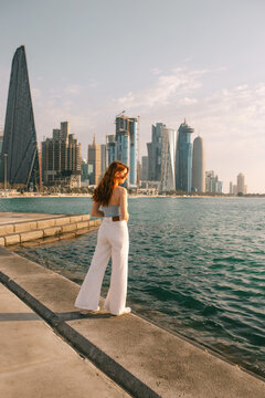 Ginger woman admiring sea from embankment