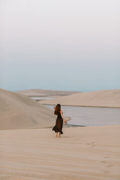Female tourist walking towards water in desert