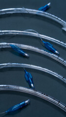 endotracheal tubes of different diameters lie on a dark background.  close-up