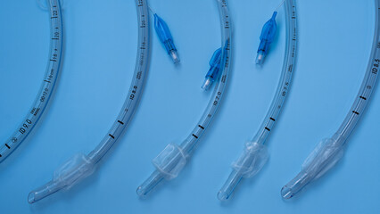 endotracheal tubes of different diameters lie on a blue background. close-up. medical instruments,...