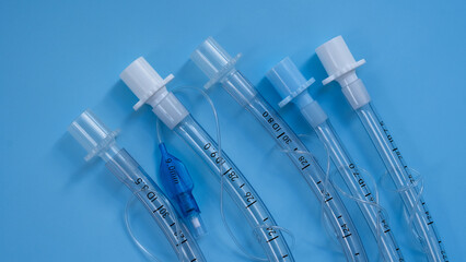 endotracheal tubes of different diameters lie on a blue background. close-up. medical instruments,...