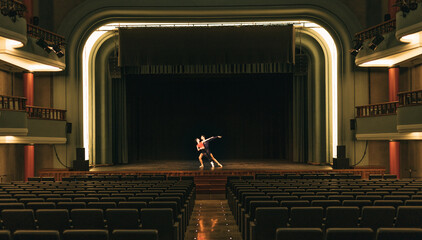Ballet dancers rehearsing on stage in empty theater