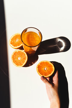 Crop woman taking orange juice