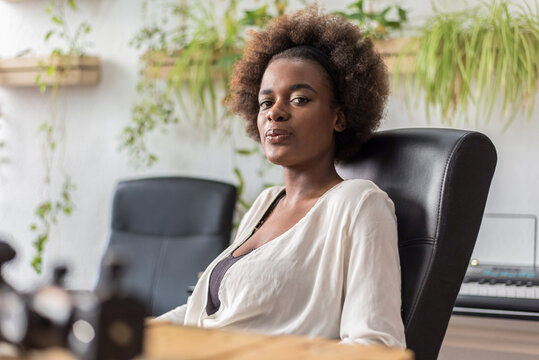 Happy black businesswoman sitting near table