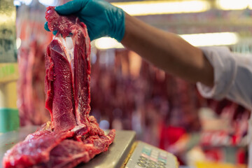 Crop butcher weighing meat during work