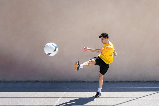 Young Male Player Kicking Football