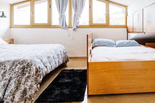 Bed built in wooden cabinet in attic room