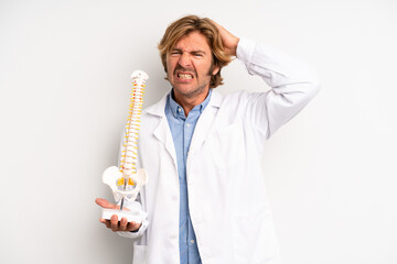 blond adult man feeling stressed, anxious or scared, with hands on head. physician or doctor concept
