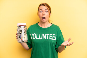 pretty blonde young woman amazed, shocked and astonished with an unbelievable surprise. donation...