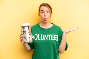 pretty blonde young woman looking surprised and shocked, with jaw dropped holding an object....