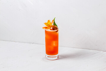 Glass of refreshing sweet orange alcoholic cocktail on white background