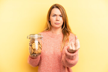 pretty blonde young woman feeling angry, annoyed, rebellious and aggressive. home made cookies...