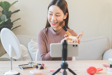 asian female beauty social media influencer livestream marketing cosmetics a make up tutorial via smartphone.