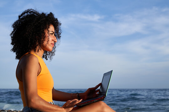 Woman Browsing Laptop On Beach