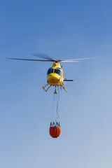 Fotobehang Emergency helicopter recharging water to extinguish a forest fire © josemperal