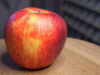 A single large ripe apple on a wooden surface. Fruit macro.