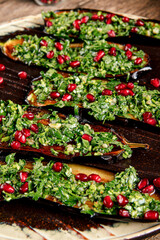 Baked aubergine appetizer with greens and pomegranate