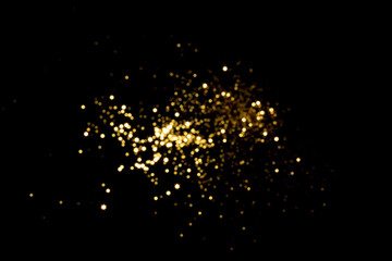 Golden blurred bokeh lights on black background. Glitter sparkle stars for celebrate