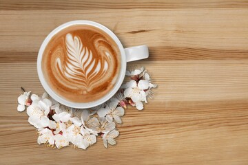 Spring composition with coffee and blooming flowers on the desk