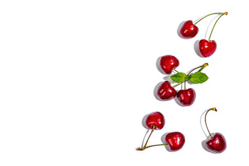 Obraz na płótnie Canvas Ripe sweet cherries with fresh mint leaves isolated on white background. Traditional summer fruits